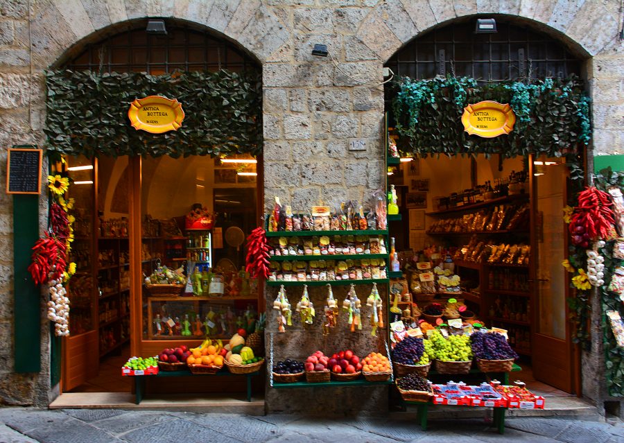 Stores, shops, restaurants, and cafés vie for visitors' attention in old Siena, Italy.