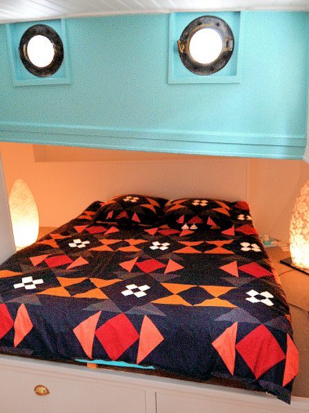 A 3rd double bedroom in its corner alcove beneath the portholes.