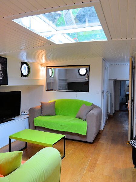 Spacious Living Room with flat-screen TV, portholes, & skylight.