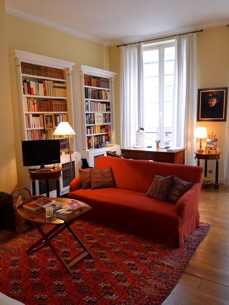 Living room with fireplace and TV plus study with writing desk and library.