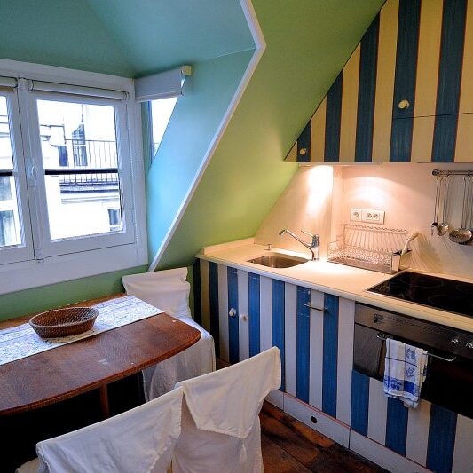 The upper floor kitchen is done in a French country style.