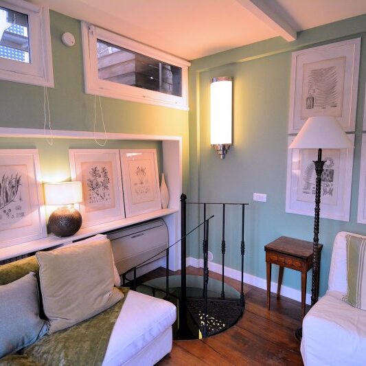 The spiral staircase leads from the lower floor to the upper floor living room.