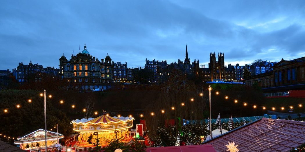 Edinburgh - Old City Silhouette behind festive East Princes Street Gardens.