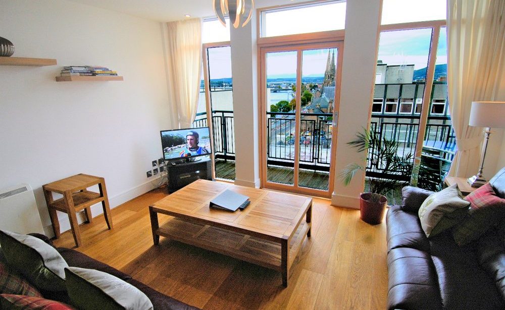 The living room with balcony and view of Inverness.