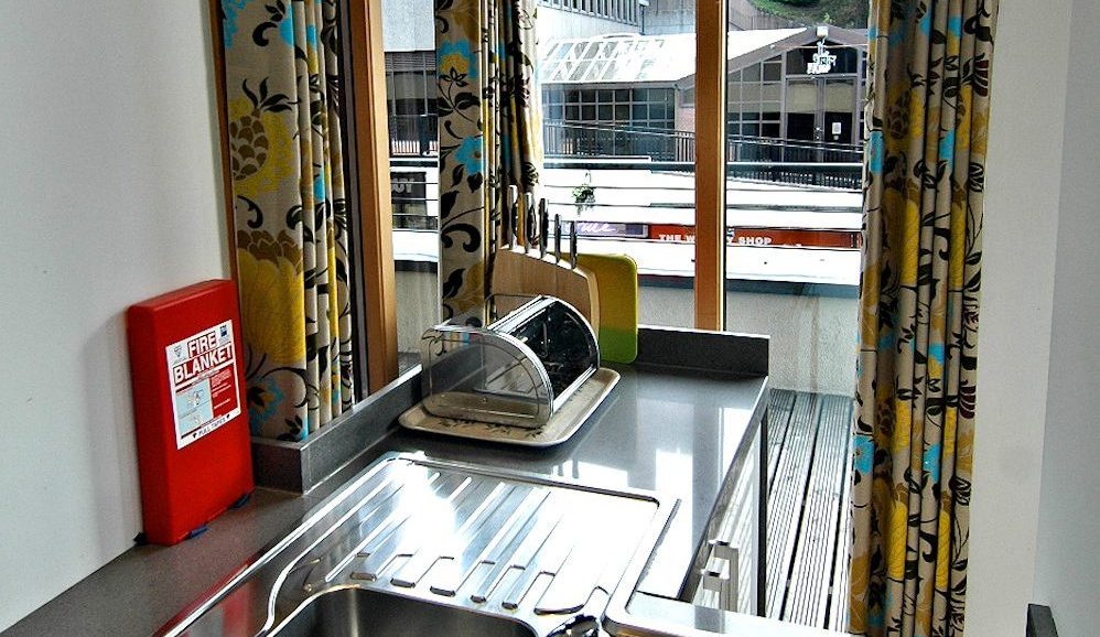 The apartment kitchen has its own access to the terrace, plus a view of Inverness Castle through the blinds.