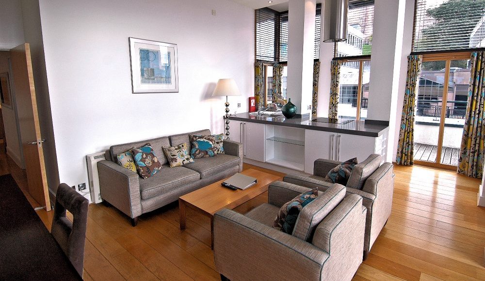 The apartment's spacious open-plan dining area, living area, and kitchen open onto the furnished terrace.