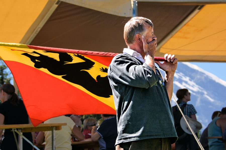 THE BERNESE OBERLAND - Bernese Flag Swinger pauses at Allmendhubel Chilbi (alpine festival) above Mürren.