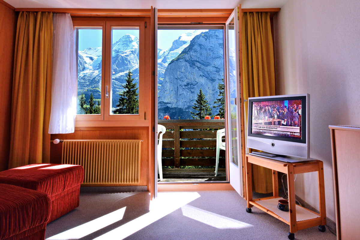 Chalet Eiger - Large Apartment - Living room with Balcony access -- Who chooses watching TV? Photo © Home At First.