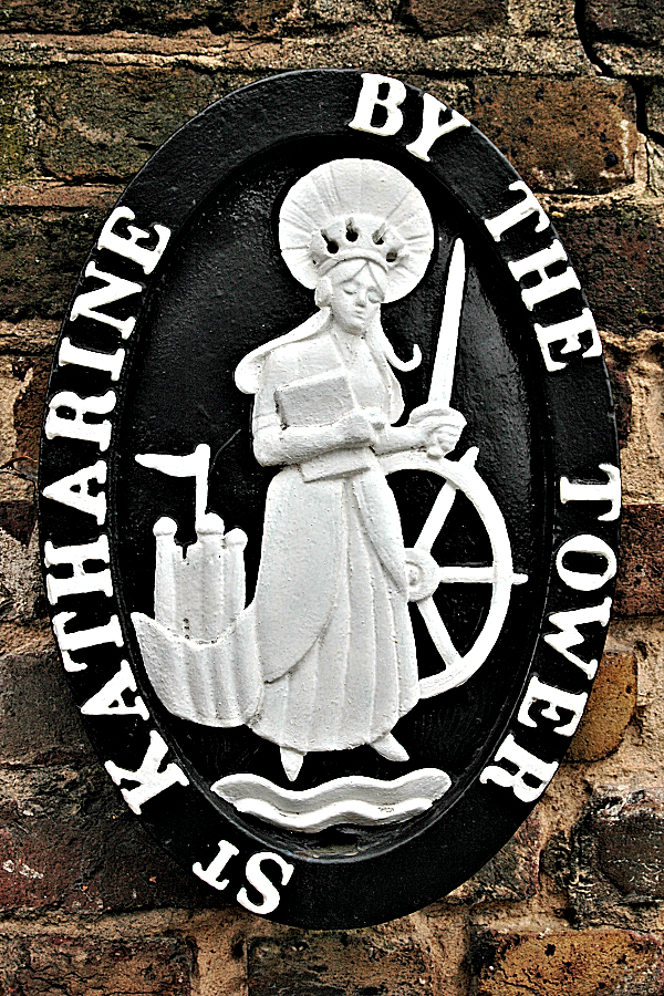 London Old & New: St Katharine by the Tower cartouche wall plaque commemorates the 12th century hospital that first occupied the space currently home to St. Katharine's Docks marina, with its modern apartments, shops, and restaurants.
