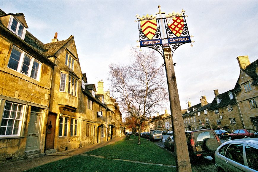 Cotswolds: High Street, Chipping Campden, with town coat of arms. Photo copyright Home At First.